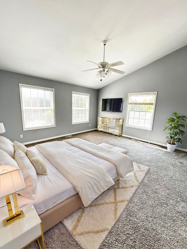 bedroom with a ceiling fan, carpet flooring, vaulted ceiling, and baseboards