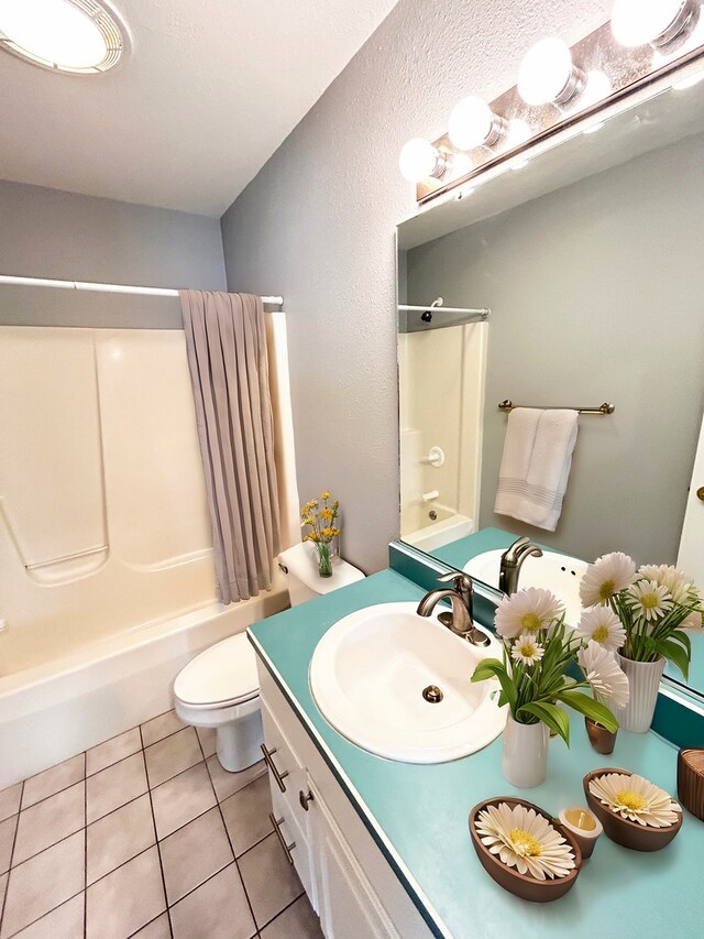 bathroom with  shower combination, vanity, tile patterned flooring, and toilet