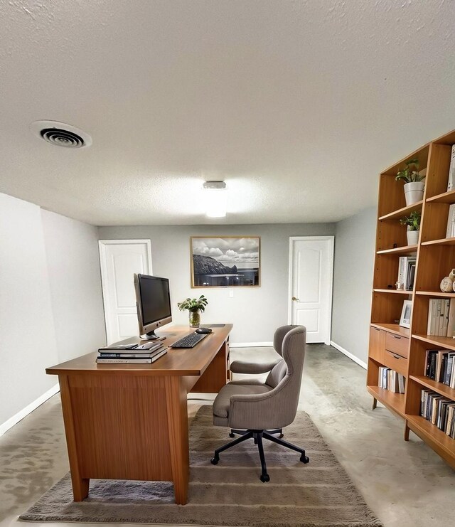 home office with baseboards, concrete floors, visible vents, and a textured ceiling