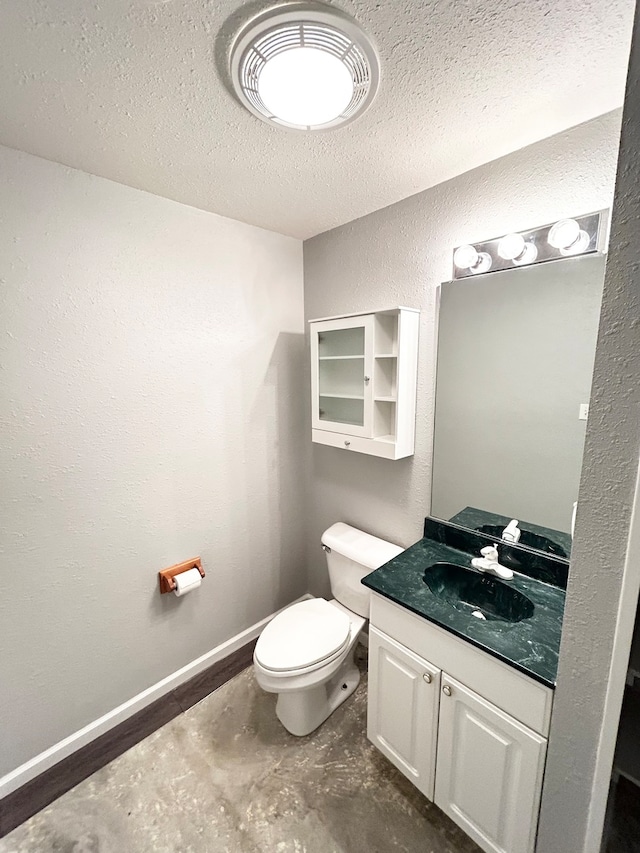 bathroom featuring a textured wall, a textured ceiling, vanity, concrete flooring, and baseboards