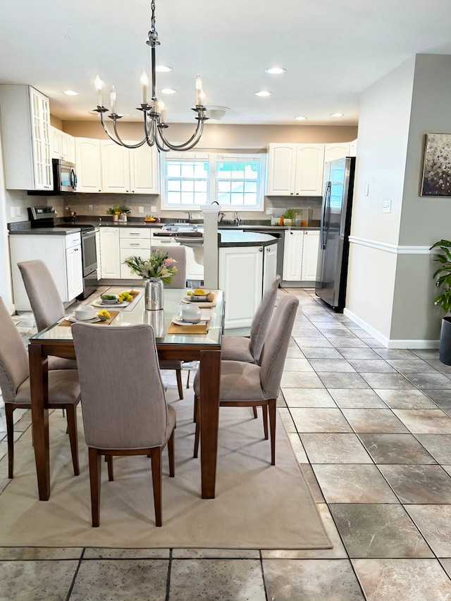 dining space with a chandelier, recessed lighting, light tile patterned flooring, and baseboards