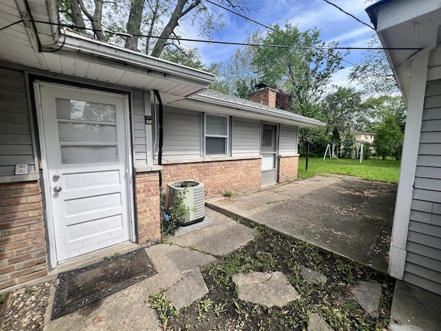 doorway to property with a yard and central AC unit