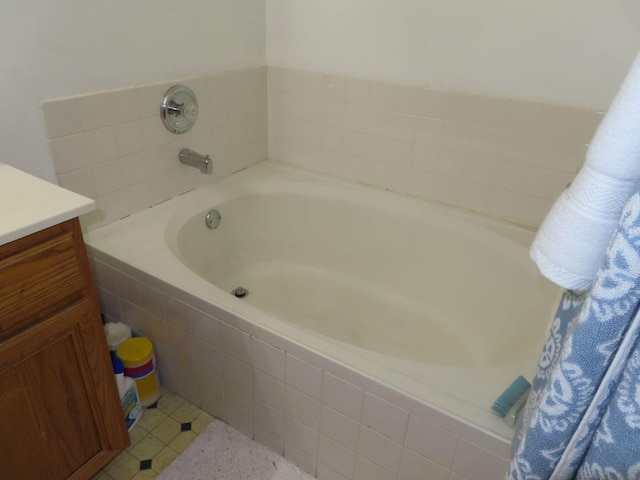 bathroom with vanity and a relaxing tiled tub