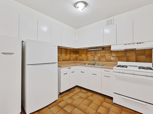 kitchen featuring tasteful backsplash, white appliances, ventilation hood, sink, and white cabinetry