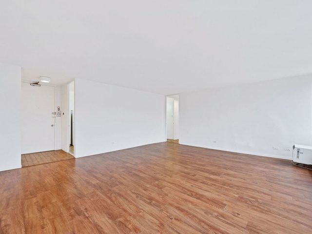 spare room with heating unit and light hardwood / wood-style flooring