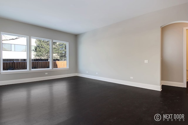 spare room with dark wood-type flooring