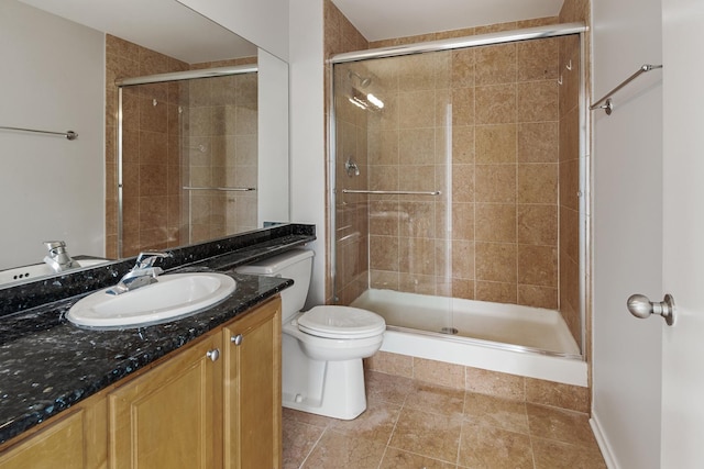 bathroom with vanity, a shower stall, and toilet