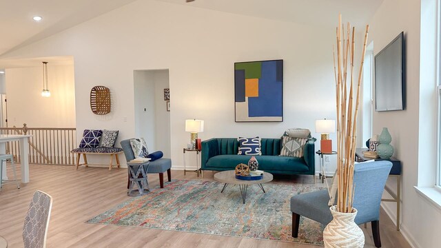 living room featuring high vaulted ceiling and light wood-type flooring