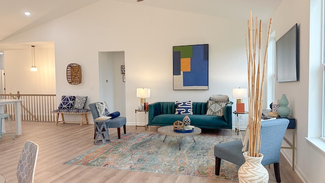 living room with vaulted ceiling, baseboards, and wood finished floors