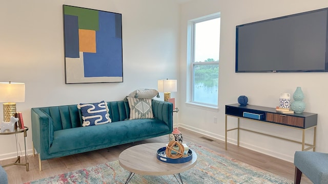 living area with visible vents, baseboards, and wood finished floors