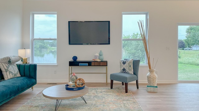 sitting room featuring light wood-type flooring, visible vents, and baseboards