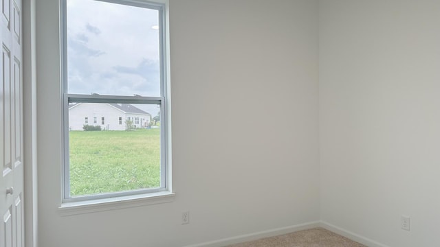 unfurnished room with carpet flooring and baseboards