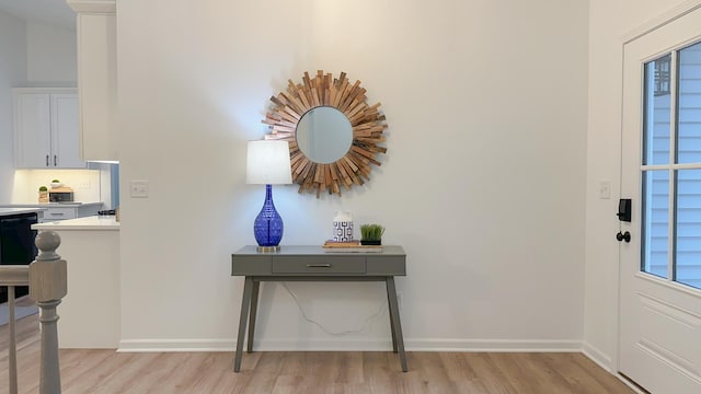 foyer with light wood-style flooring and baseboards