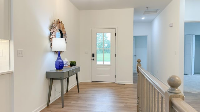 doorway featuring light wood-style flooring and baseboards