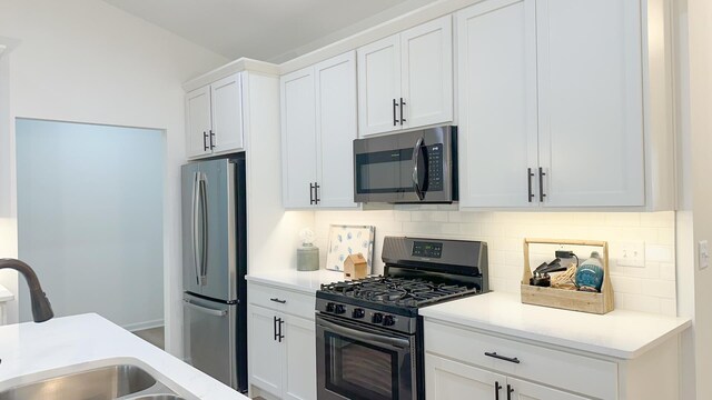 kitchen with white cabinets, tasteful backsplash, appliances with stainless steel finishes, and sink