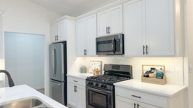 kitchen featuring light countertops, appliances with stainless steel finishes, a sink, and white cabinets