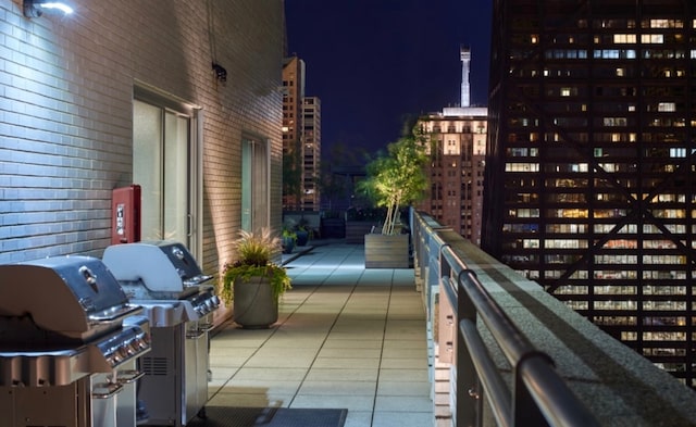 balcony at night featuring grilling area