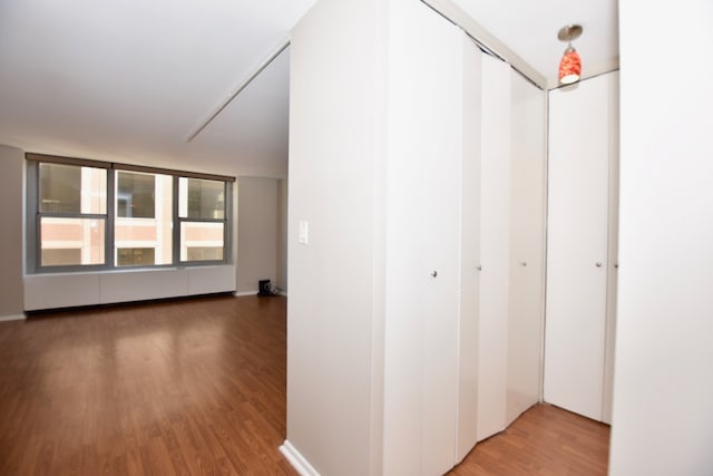 corridor with hardwood / wood-style floors