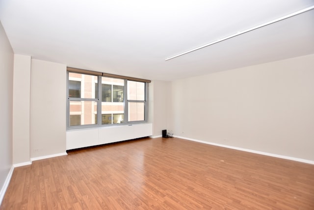 unfurnished room with hardwood / wood-style flooring