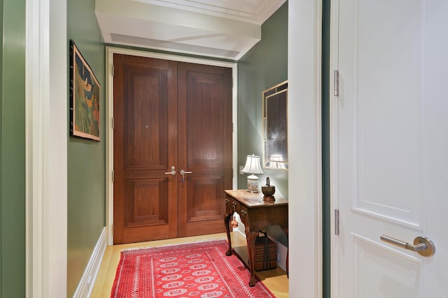 doorway featuring crown molding and light wood-type flooring