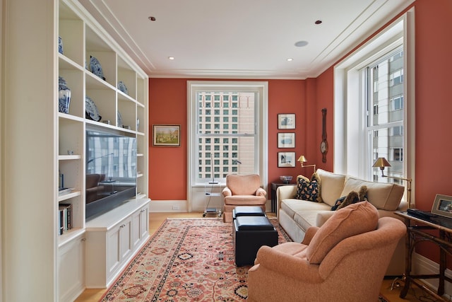 living room with light hardwood / wood-style floors and ornamental molding