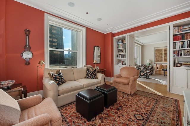 living area with wood-type flooring, built in features, and ornamental molding