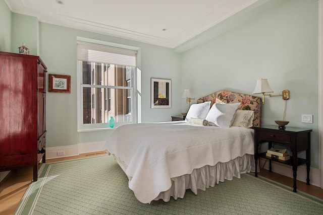 bedroom with hardwood / wood-style floors and ornamental molding