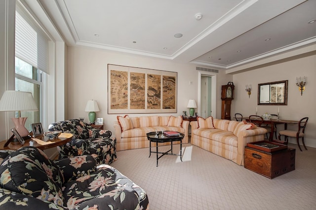 carpeted living room with ornamental molding and a tray ceiling