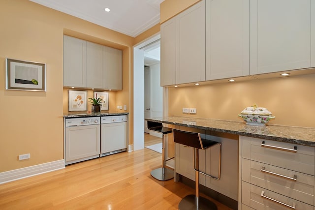 kitchen with white cabinets, light hardwood / wood-style flooring, white dishwasher, and stone countertops