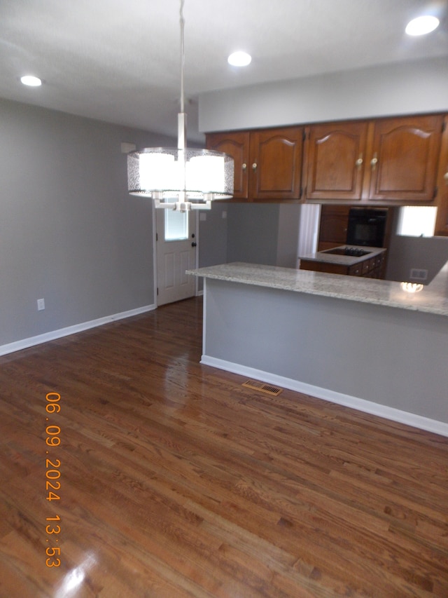 kitchen featuring kitchen peninsula, dark hardwood / wood-style floors, and an inviting chandelier