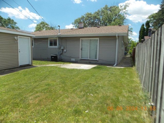 back of property featuring a yard and central air condition unit