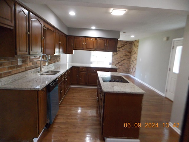 kitchen with dark hardwood / wood-style flooring, black electric cooktop, sink, dishwasher, and a center island