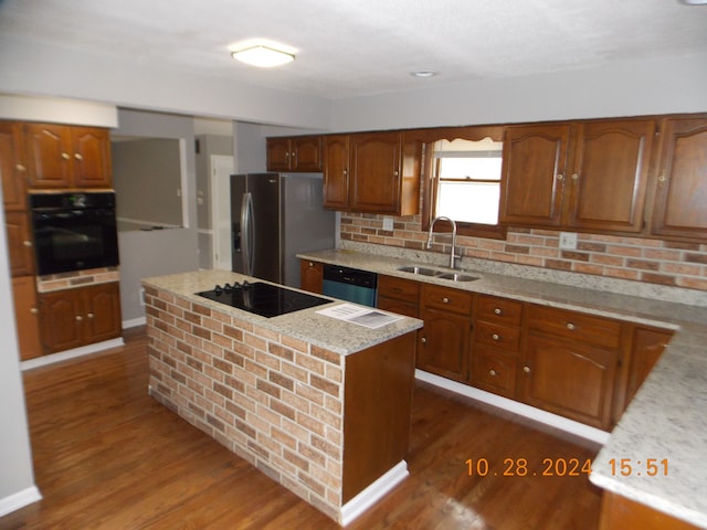 kitchen featuring a center island, backsplash, dark wood-type flooring, black appliances, and sink