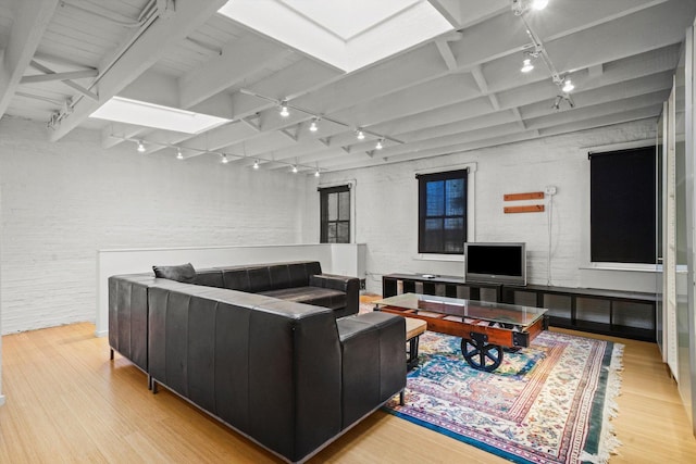 living room with beam ceiling and light wood-type flooring