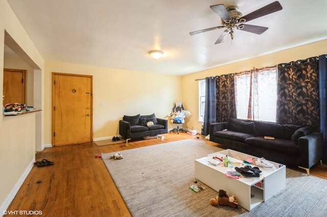 living room with wood-type flooring and ceiling fan