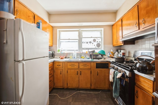 kitchen featuring dark parquet flooring, sink, backsplash, and stainless steel appliances