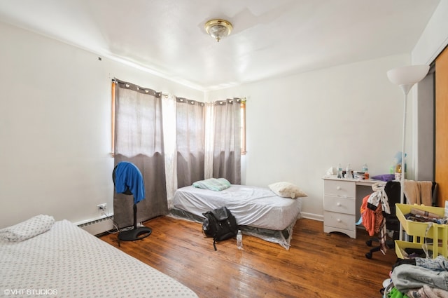 bedroom featuring baseboard heating and dark wood-type flooring