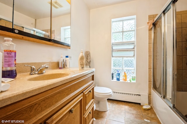 full bathroom with oversized vanity, baseboard heating, enclosed tub / shower combo, tile floors, and toilet