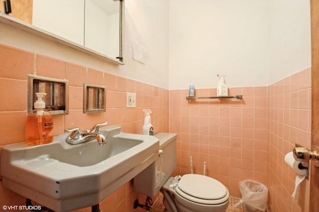 bathroom with sink, tasteful backsplash, toilet, and tile walls