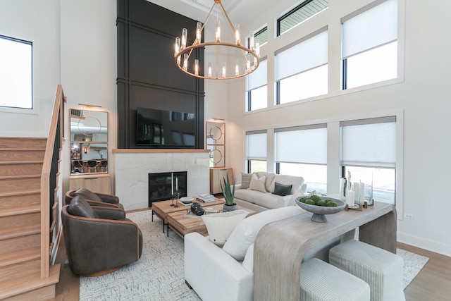 15W601 Grant St, Burr Ridge, IL 60527 - living room with a fireplace, a towering ceiling, a chandelier, and light wood-type flooring