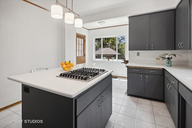 kitchen featuring a kitchen island, crown molding, light countertops, and stainless steel gas cooktop