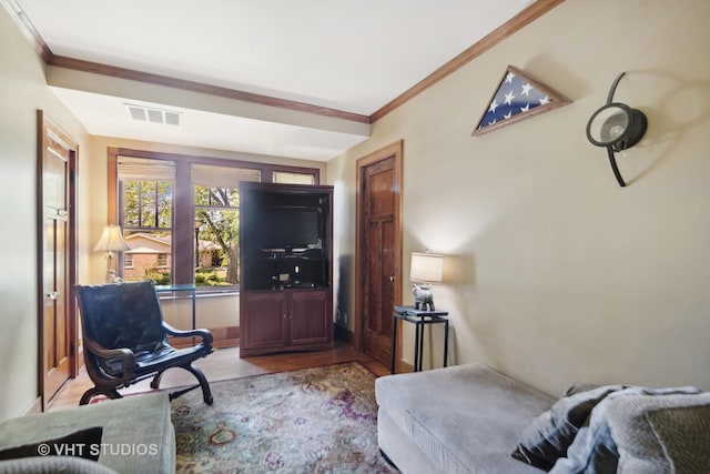 living area featuring visible vents, crown molding, and baseboards