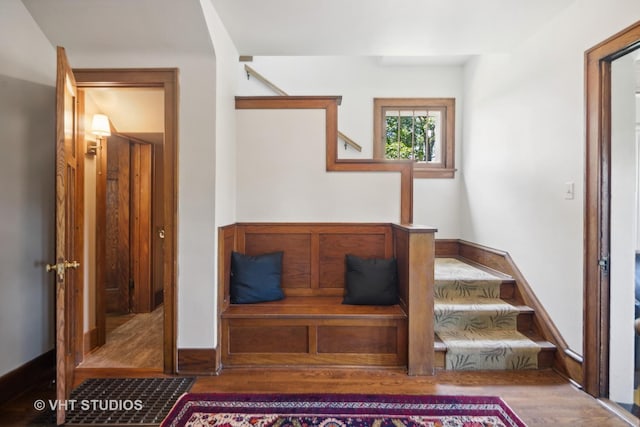 staircase featuring baseboards and wood finished floors