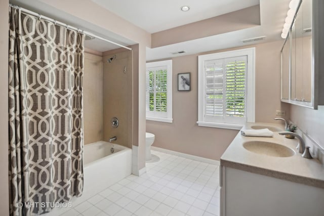 bathroom with toilet, a sink, tile patterned flooring, double vanity, and baseboards