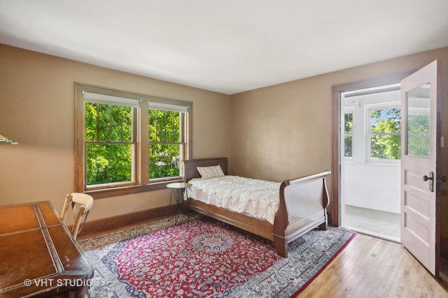 bedroom with wood finished floors and baseboards