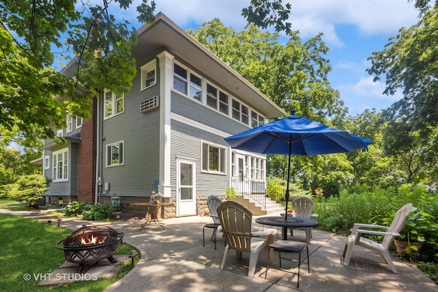 back of property with a patio and an outdoor fire pit