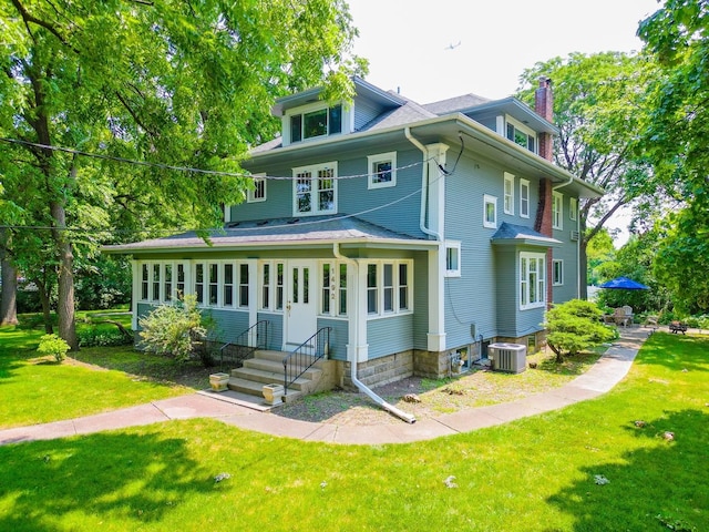 rear view of house featuring a yard, central AC unit, a chimney, and entry steps