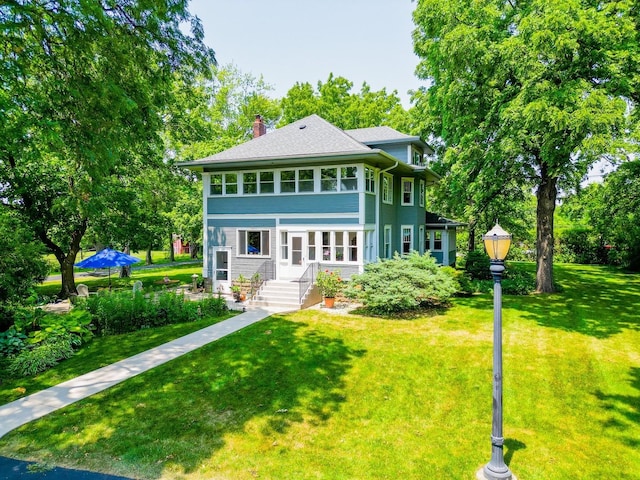 view of front of house featuring a front lawn and a chimney