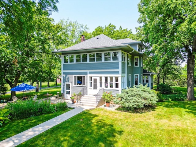 view of front of home with a chimney and a front yard