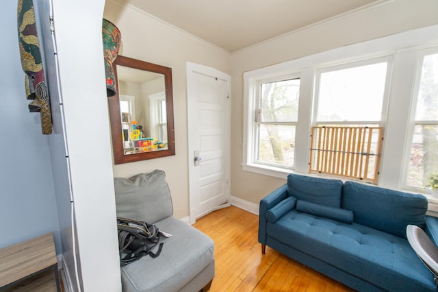 sitting room with crown molding and wood-type flooring